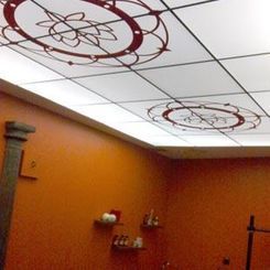 Habitación naranja con paneles de techo blancos y diseños decorativos circulares rojos.