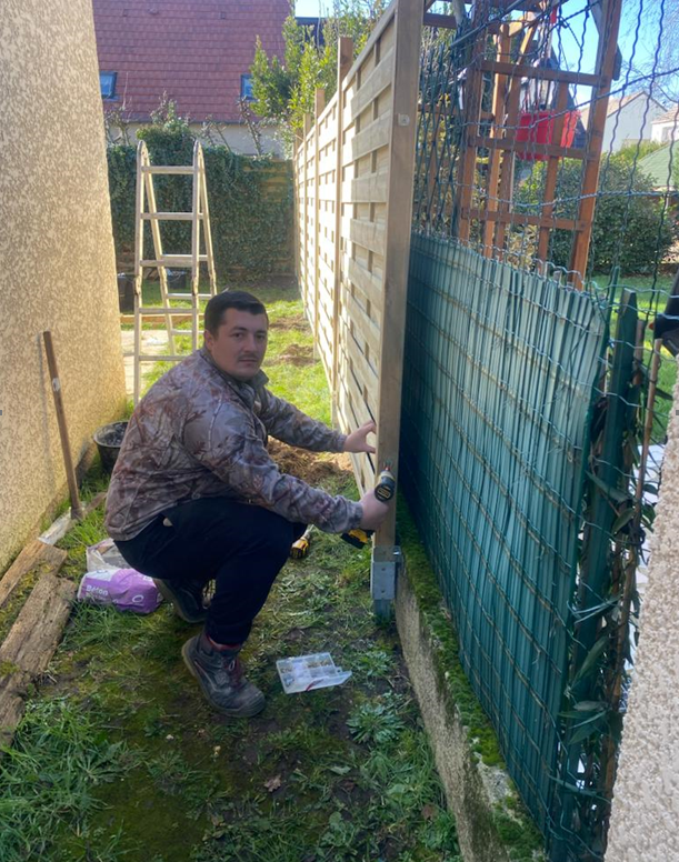 Un artisan pose une clôture