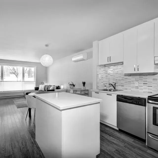 Una fotografía en blanco y negro de una cocina con electrodomésticos de acero inoxidable.