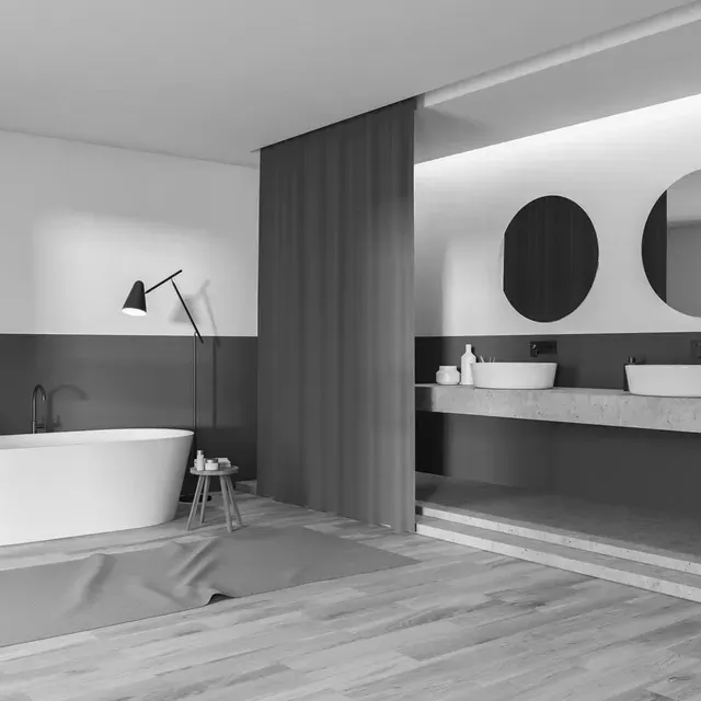 Una fotografía en blanco y negro de un baño con bañera y dos lavabos.