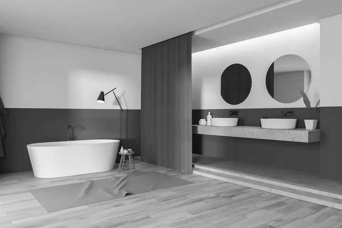 Una fotografía en blanco y negro de un baño con bañera y dos lavabos.