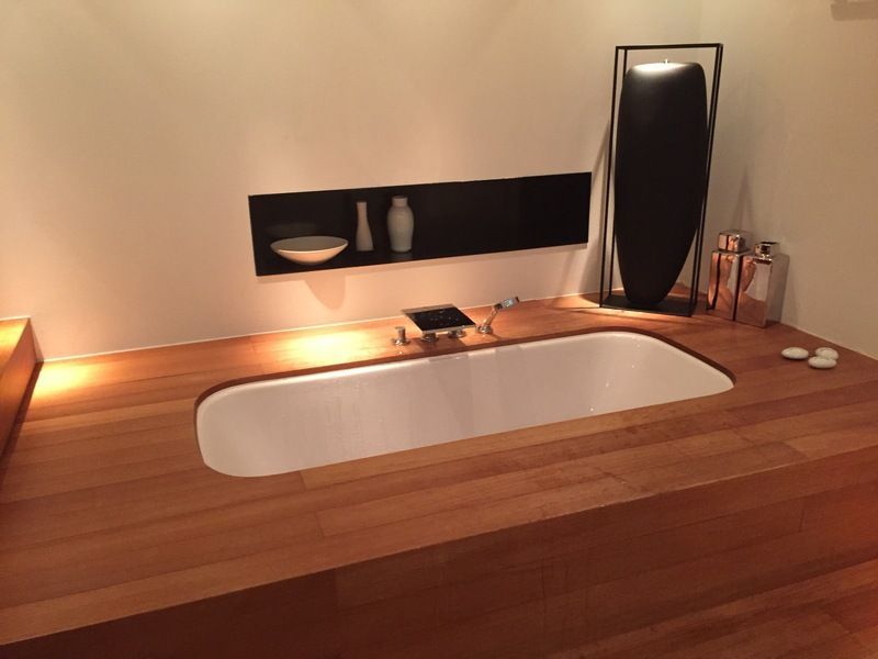 Lavabo de salle de bain moderne avec plan de travail en bois, vasque rectangulaire, miroir et éclairage chaleureux