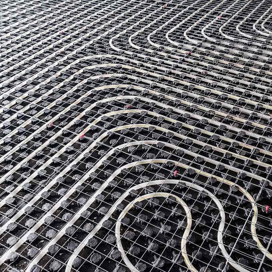 Des câbles blancs incurvés, disposés sur une grille métallique noire, créent un motif abstrait ondulé.