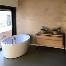 Salle de bains moderne avec baignoire blanche, double vasque et grande fenêtre