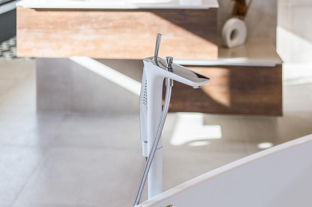 Gros plan d'une pince ou d'un support en métal blanc fixé à une surface courbe dans un environnement intérieur lumineux