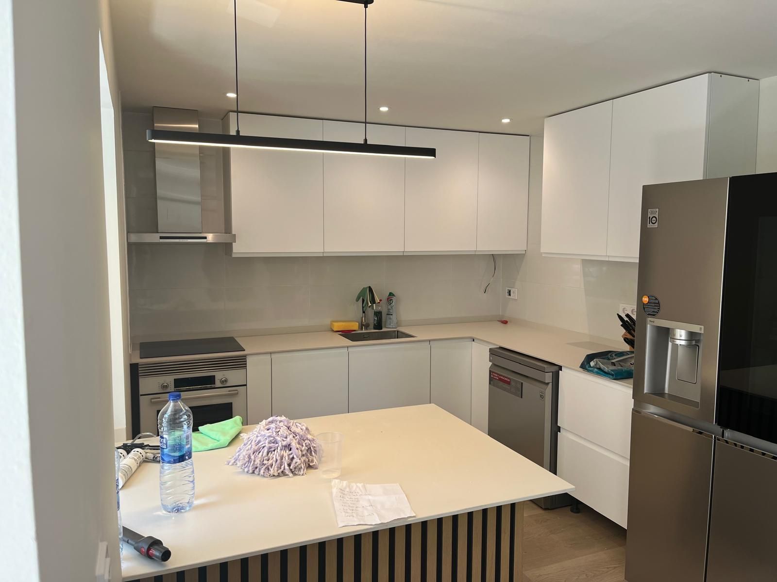 Baño moderno con paneles de madera, lavabos dobles, bañera y taburete de madera.