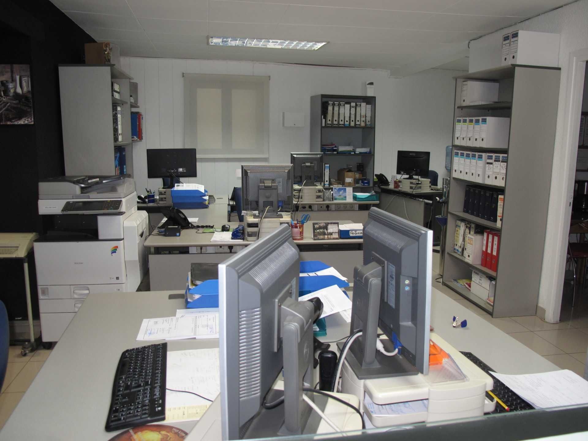 Hay dos monitores de computadora sobre un escritorio en una oficina.