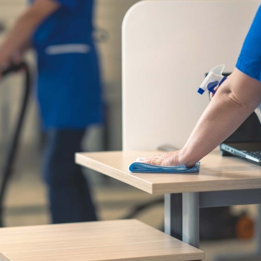 Employée nettoyant une table