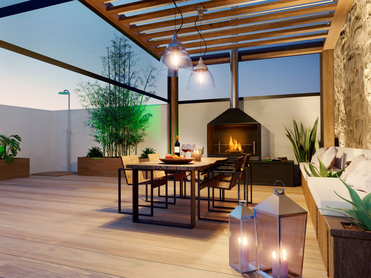 Terrasse extérieure avec table à manger, cheminée et banquettes intégrées. Décoration nocturne avec lanternes et suspensions.
