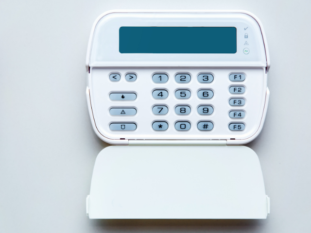 Un clavier de sécurité blanc avec un affichage sur une surface blanche.