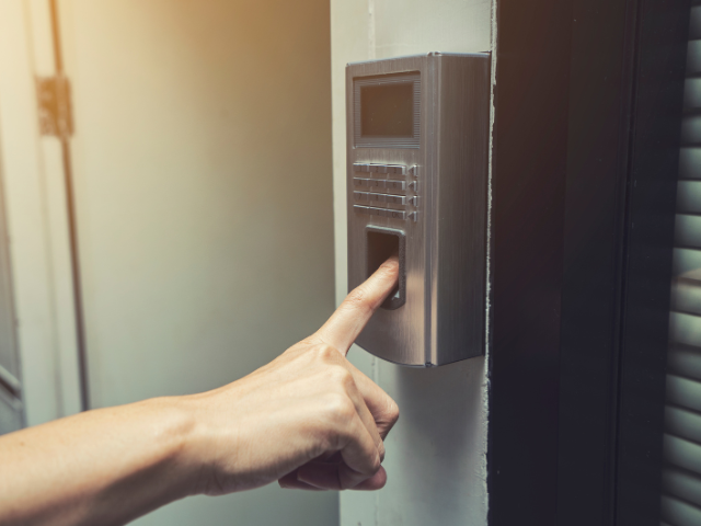 Une personne appuie sur un bouton d'une porte avec son doigt.