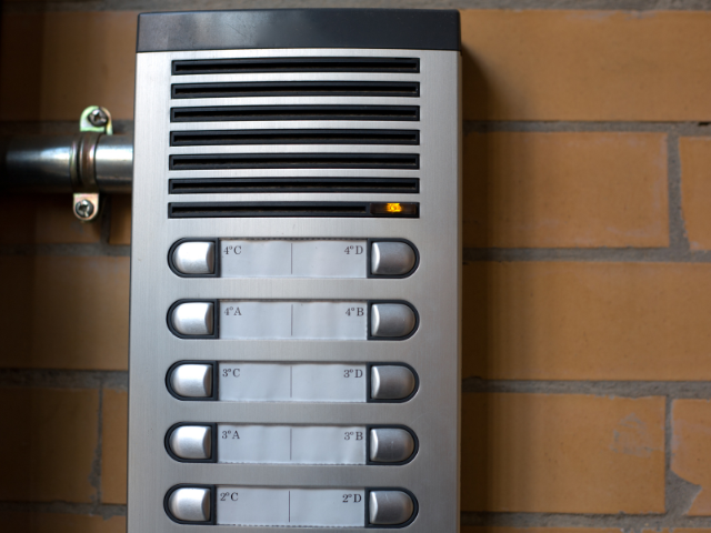 Un mur de briques avec une sonnette sur laquelle sont inscrites les lettres fa