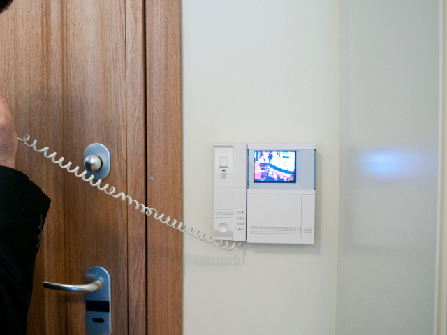 Un homme parle au téléphone alors qu'il se tient devant une porte.