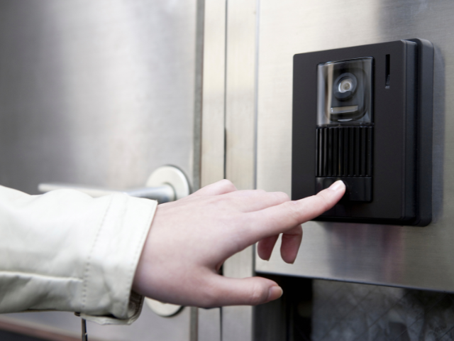 Une personne appuie sur une sonnette avec son doigt