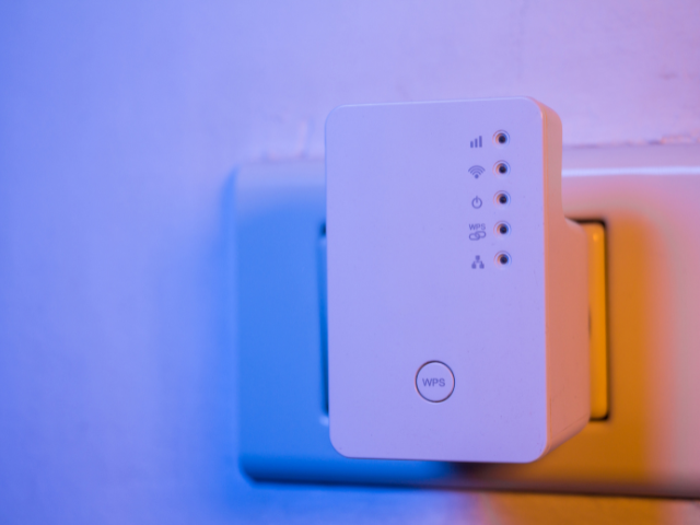 Un routeur blanc est branché sur une prise murale.