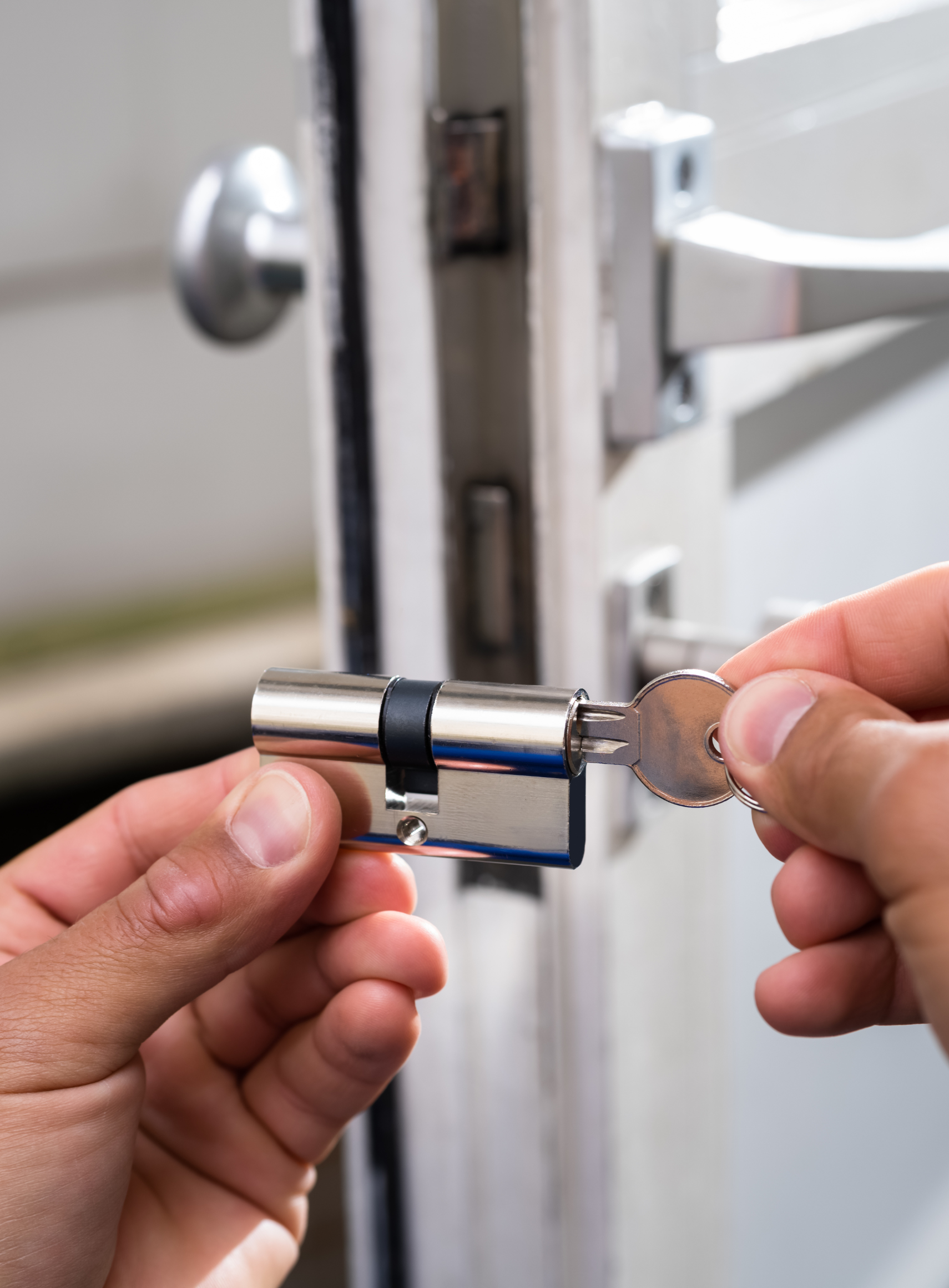 Une personne tient une clé devant une porte.