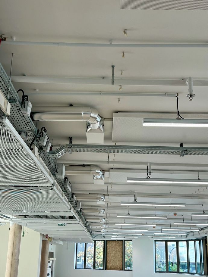 Plafond avec tuyaux, lumières et motif d'illusion d'optique.