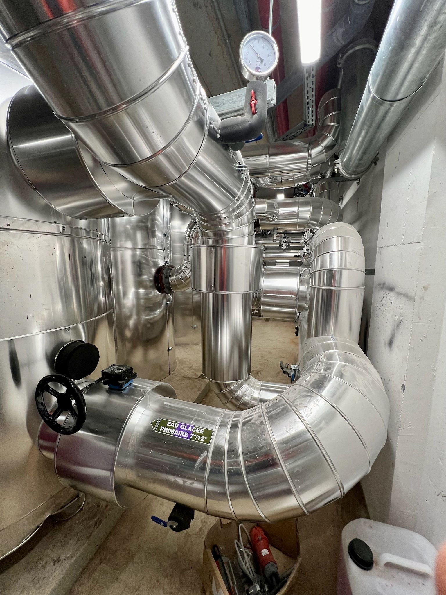 Tuyaux et vannes métalliques isolés en milieu industriel.