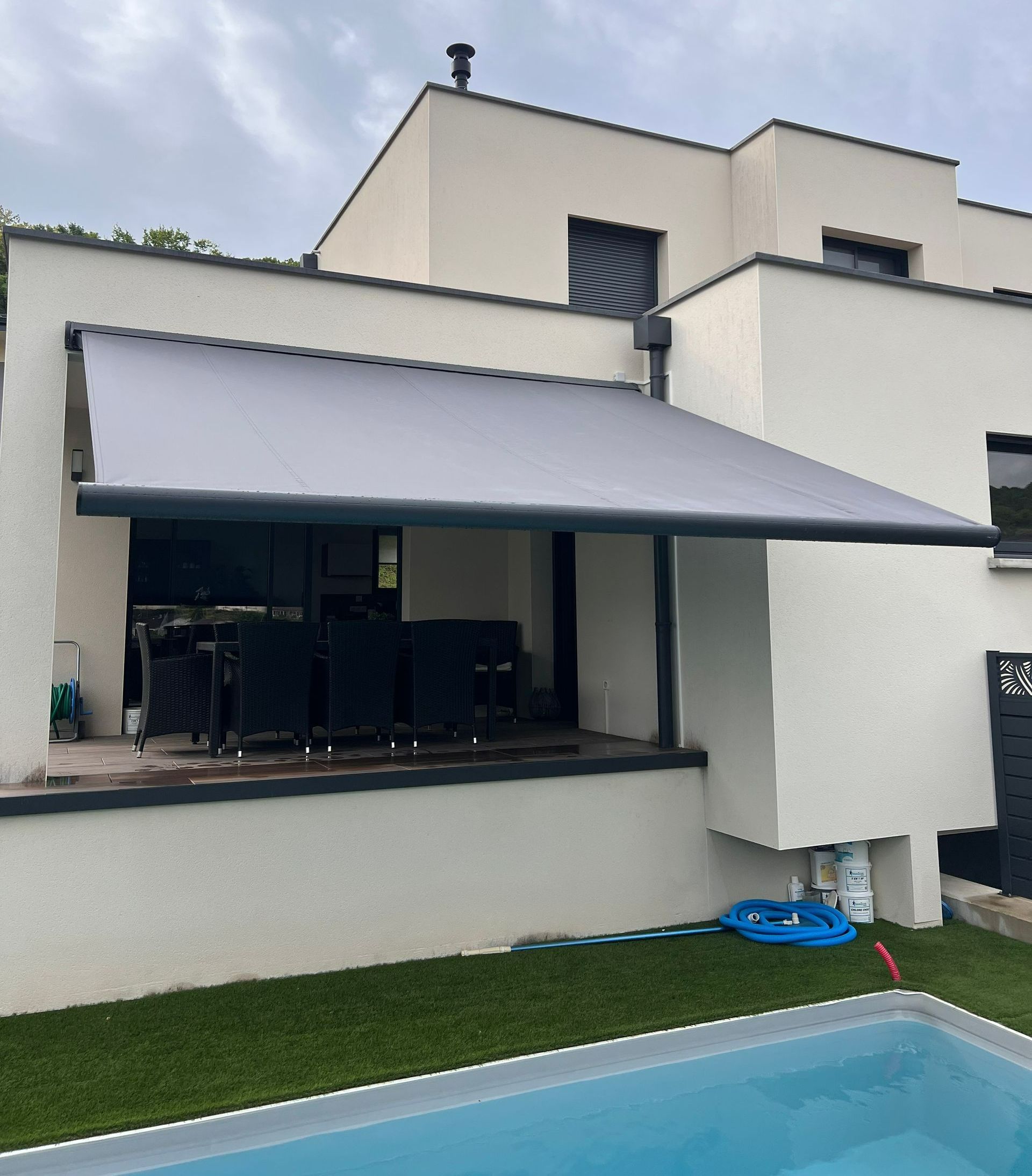 Une maison avec un store et une piscine