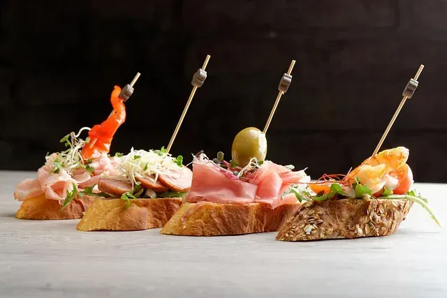 Tres bocadillos con carne y verduras en palillos sobre una mesa.