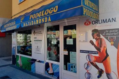 Una tienda con un toldo azul que dice podólogo.