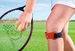 Una mujer sostiene una raqueta de tenis y una pelota de tenis.