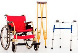 Una silla de ruedas, muletas y un andador sobre un fondo blanco.