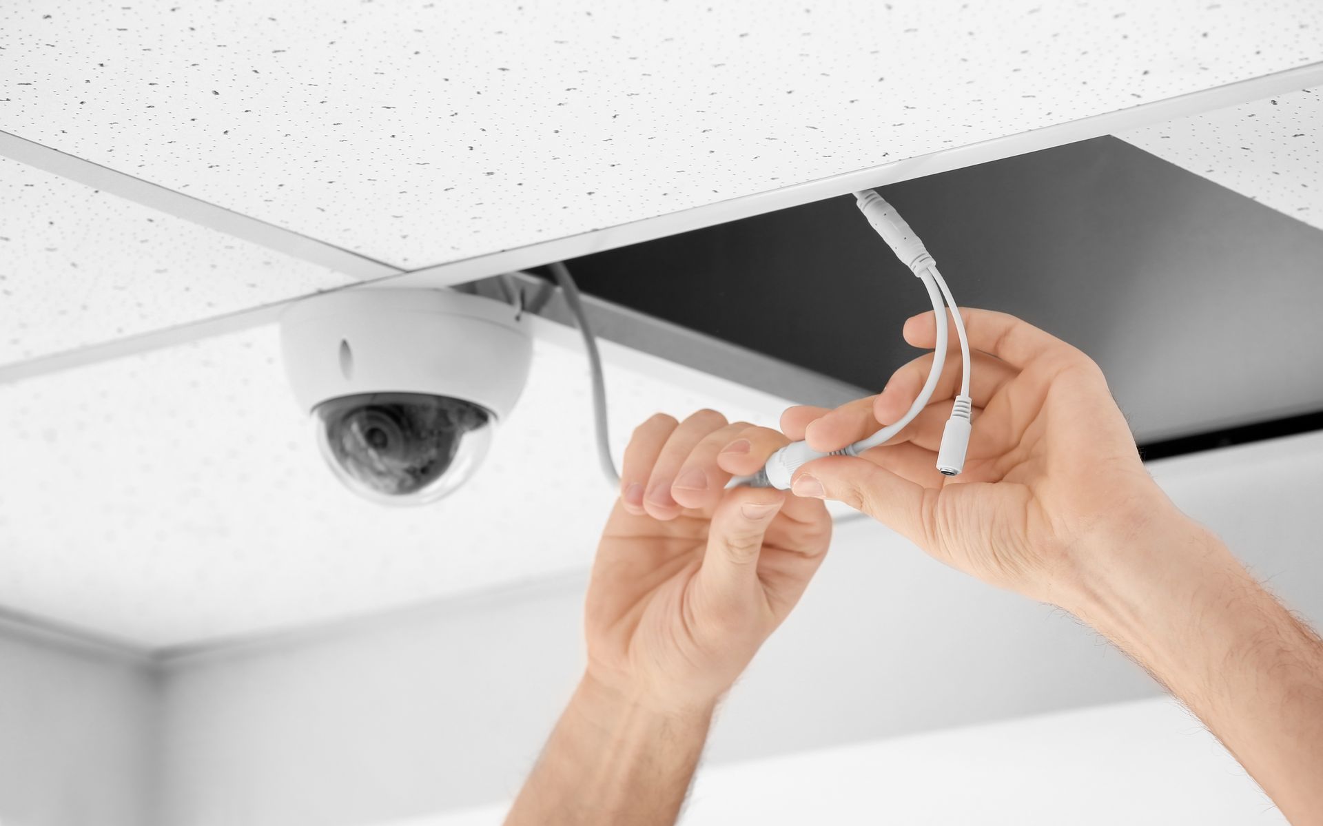 Technicien procédant au branchement d'une caméra de vidéosurveillance