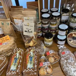 Assortiment de pâtisseries maison, de bocaux et de collations emballées présentés sur une table.