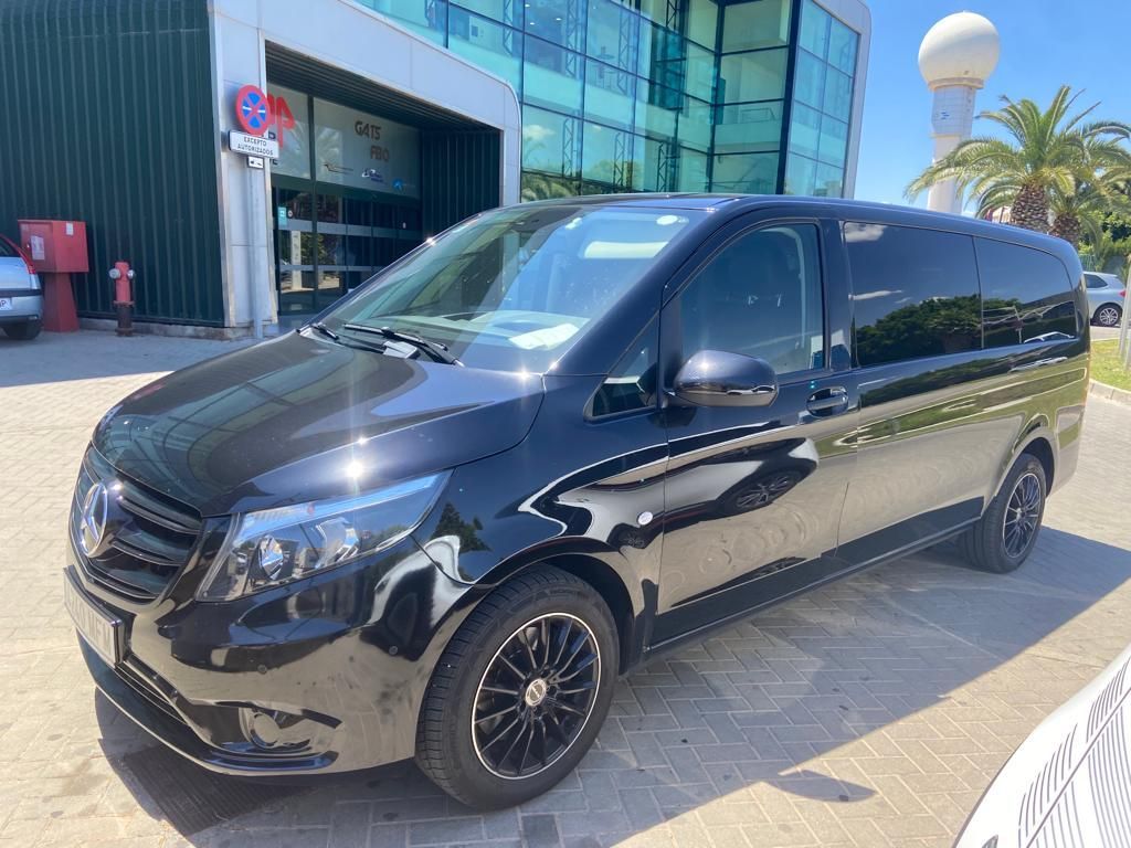 Una camioneta negra está estacionada frente a un edificio.