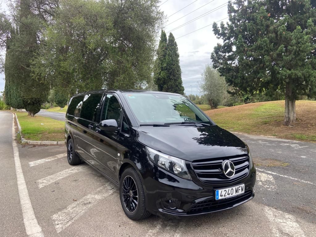 Una camioneta Mercedes negra está estacionada al costado de la carretera.