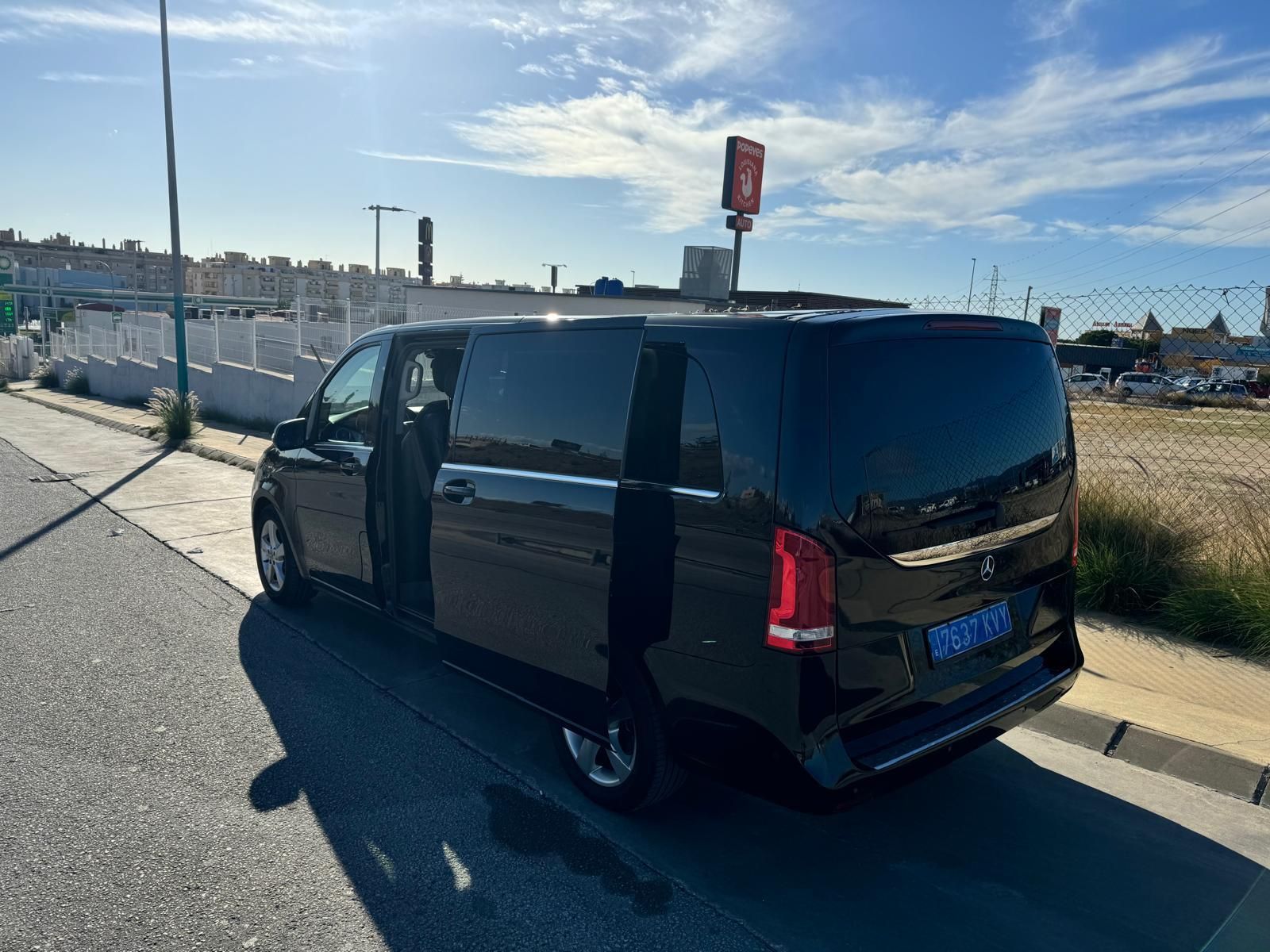 Una camioneta negra está estacionada al costado de la carretera con las puertas abiertas.