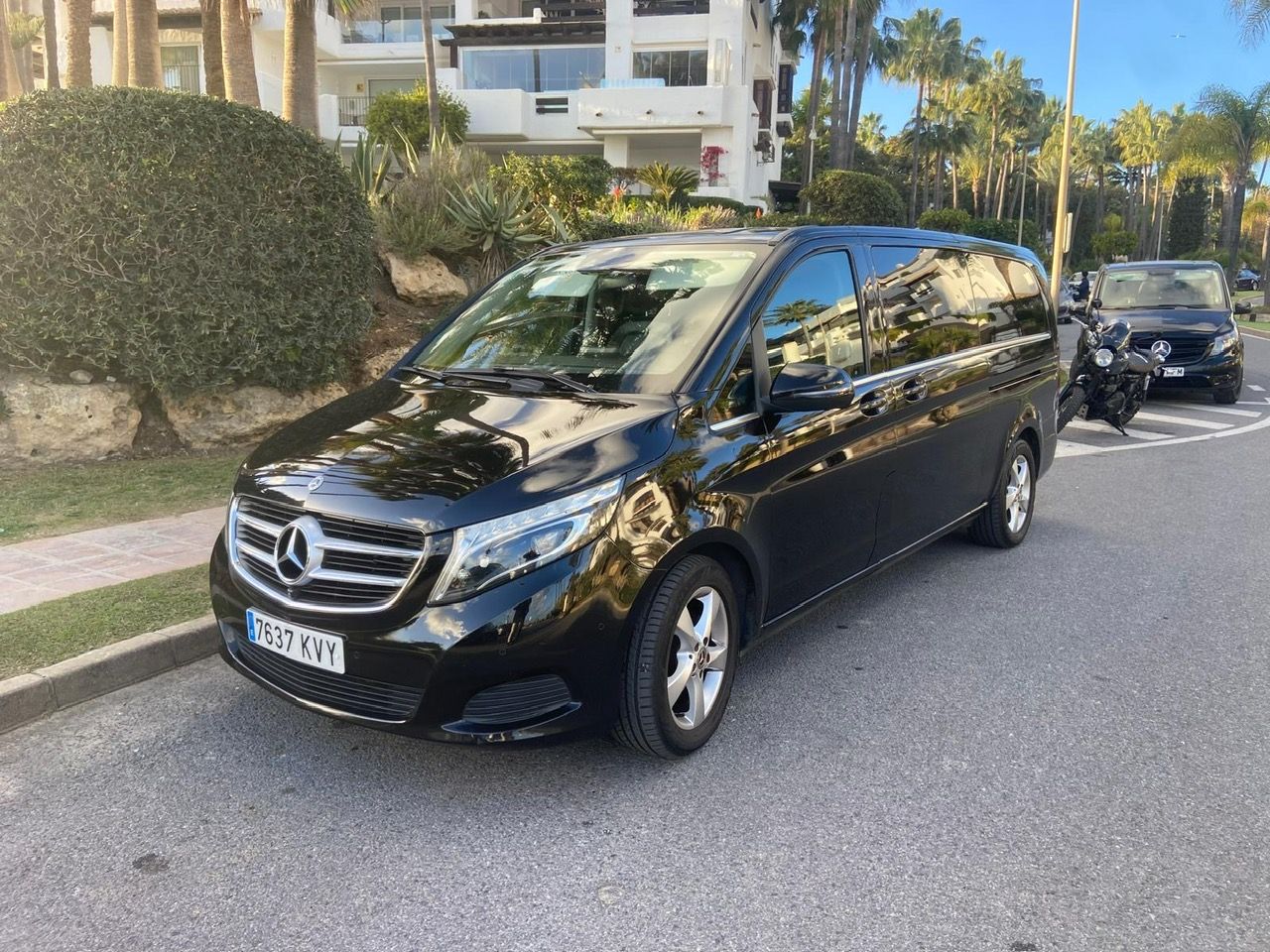 Una camioneta Mercedes negra está estacionada al costado de la carretera.