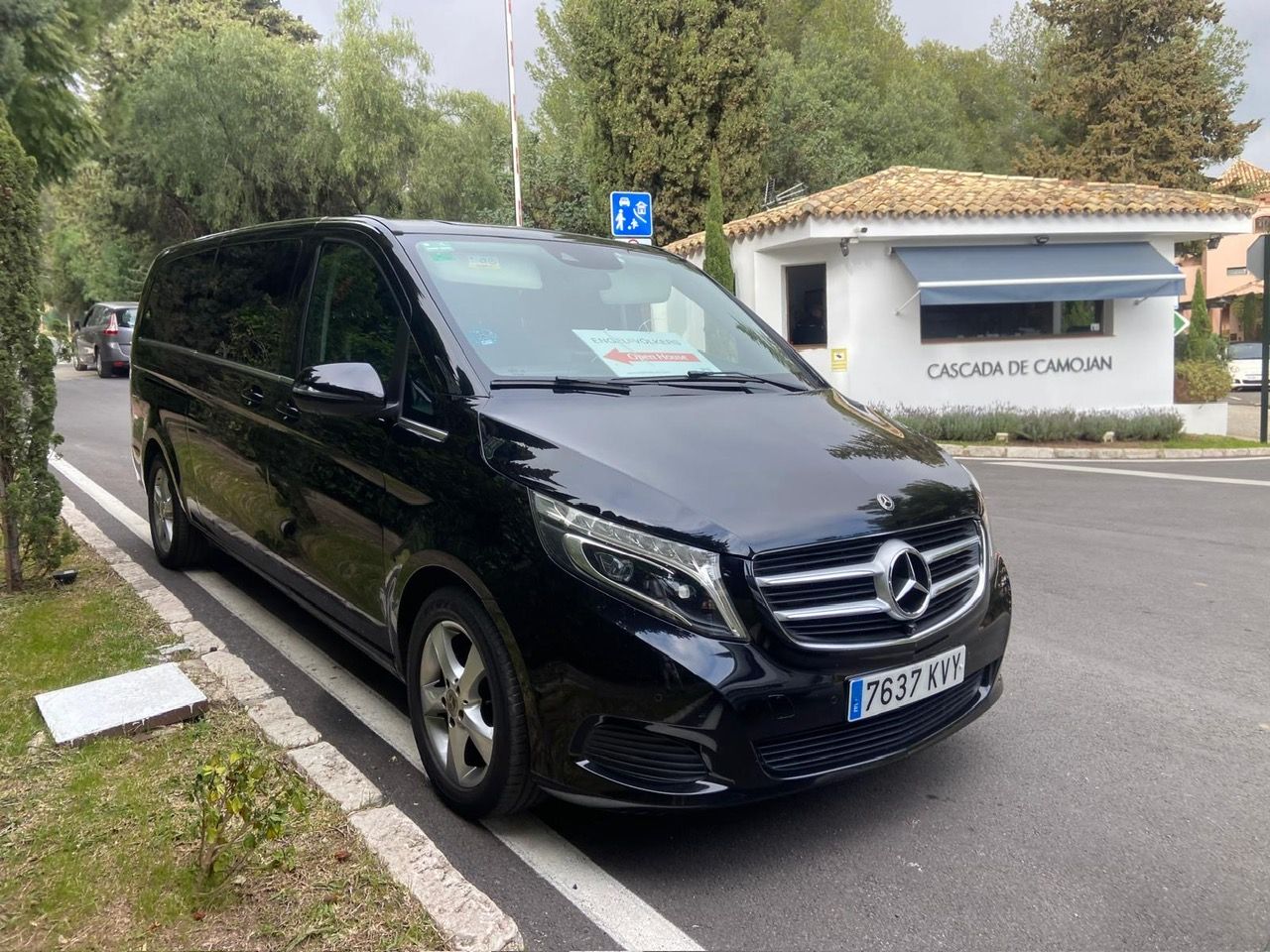 Una camioneta Mercedes negra está estacionada al costado de la carretera.