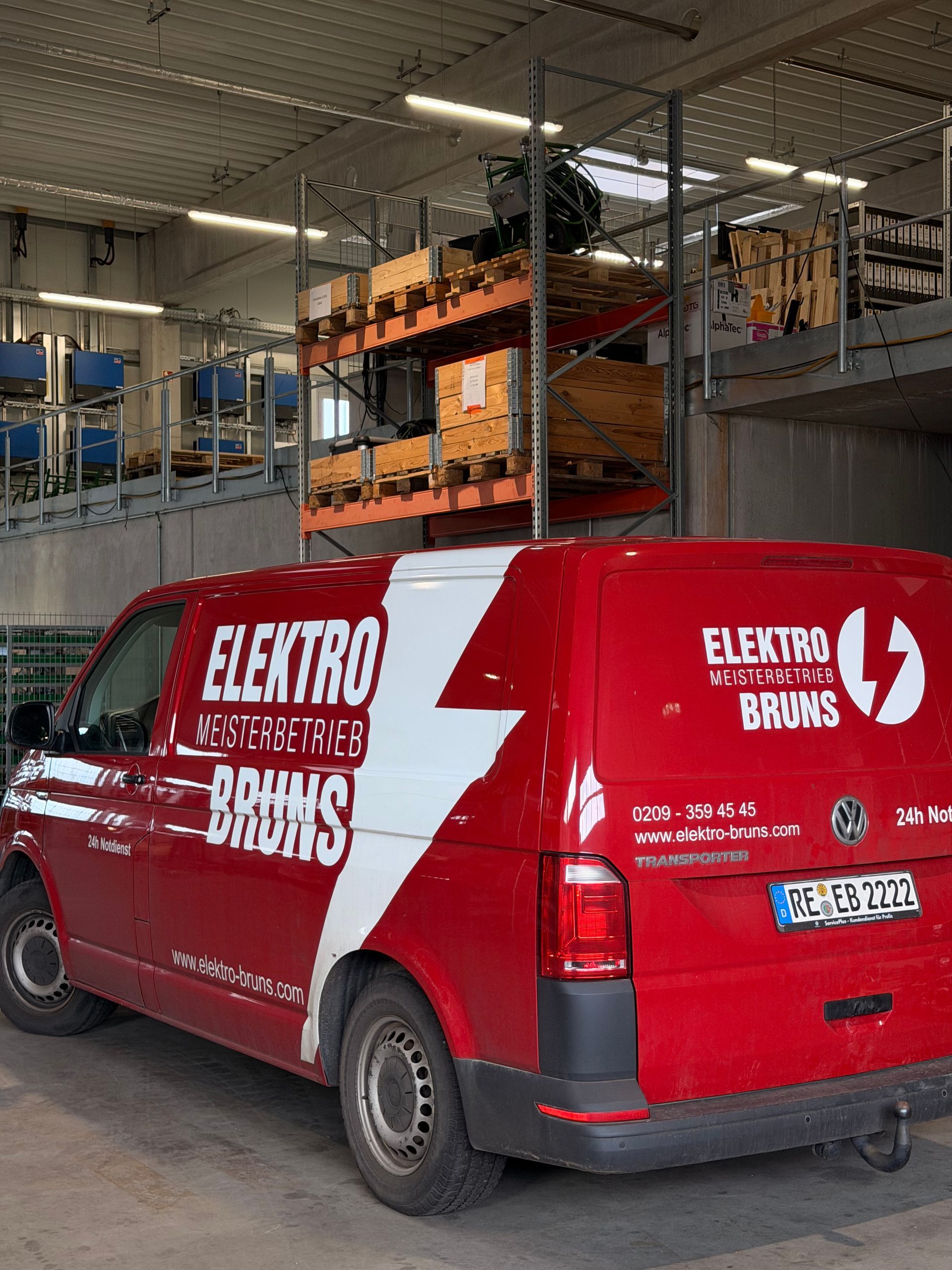 Ein roter Lieferwagen der Marke Electric steht in einer Industriegarage unter einer Hebebühne.