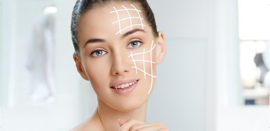 Mujer aplicándose productos para el cuidado facial con líneas blancas de tratamiento en su rostro, en un baño luminoso.
