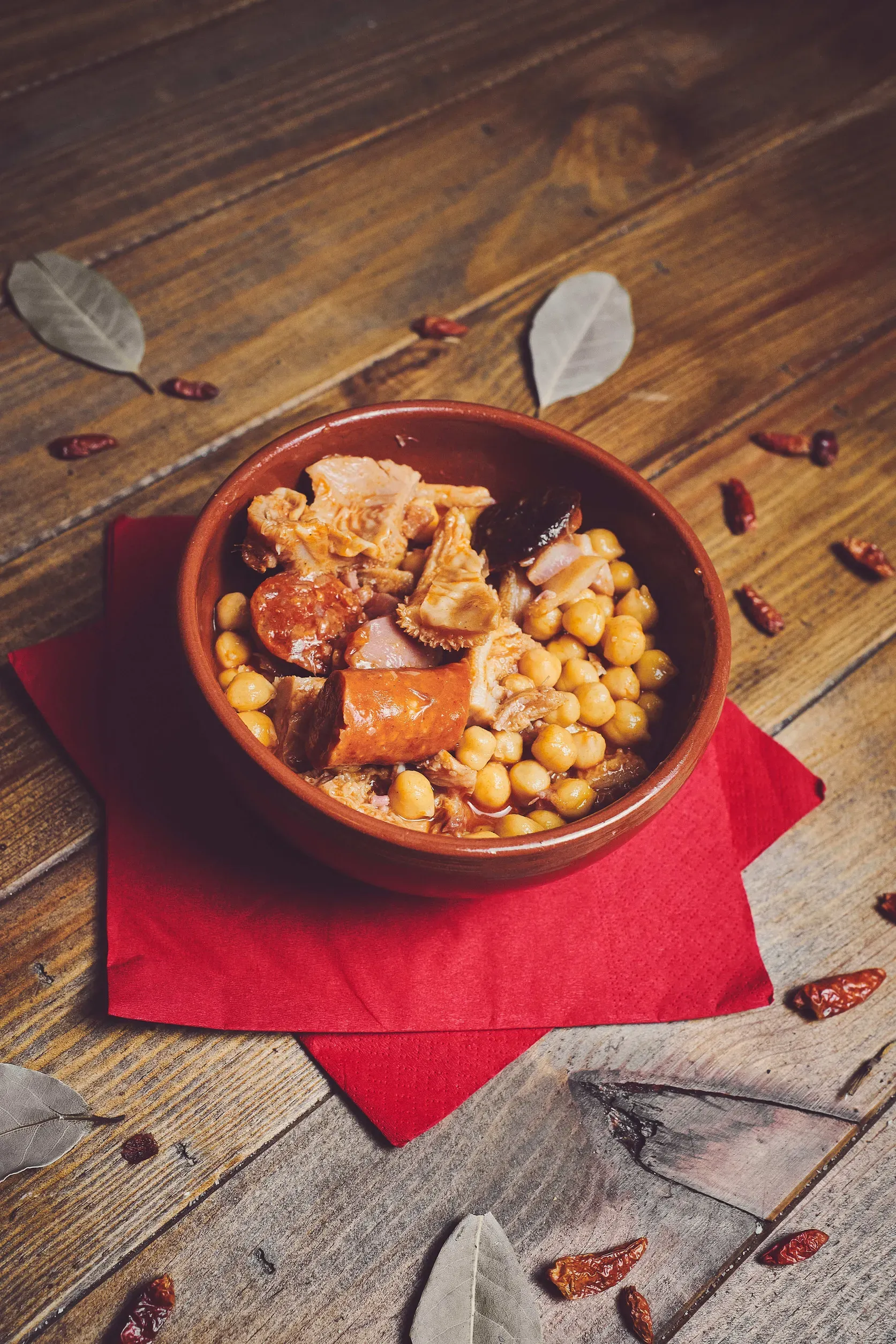Un plato de comida está sobre una servilleta roja sobre una mesa de madera.
