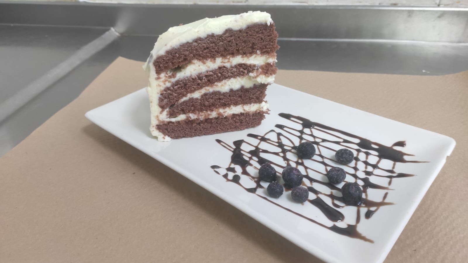 Una rebanada de pastel de chocolate con arándanos en un plato blanco