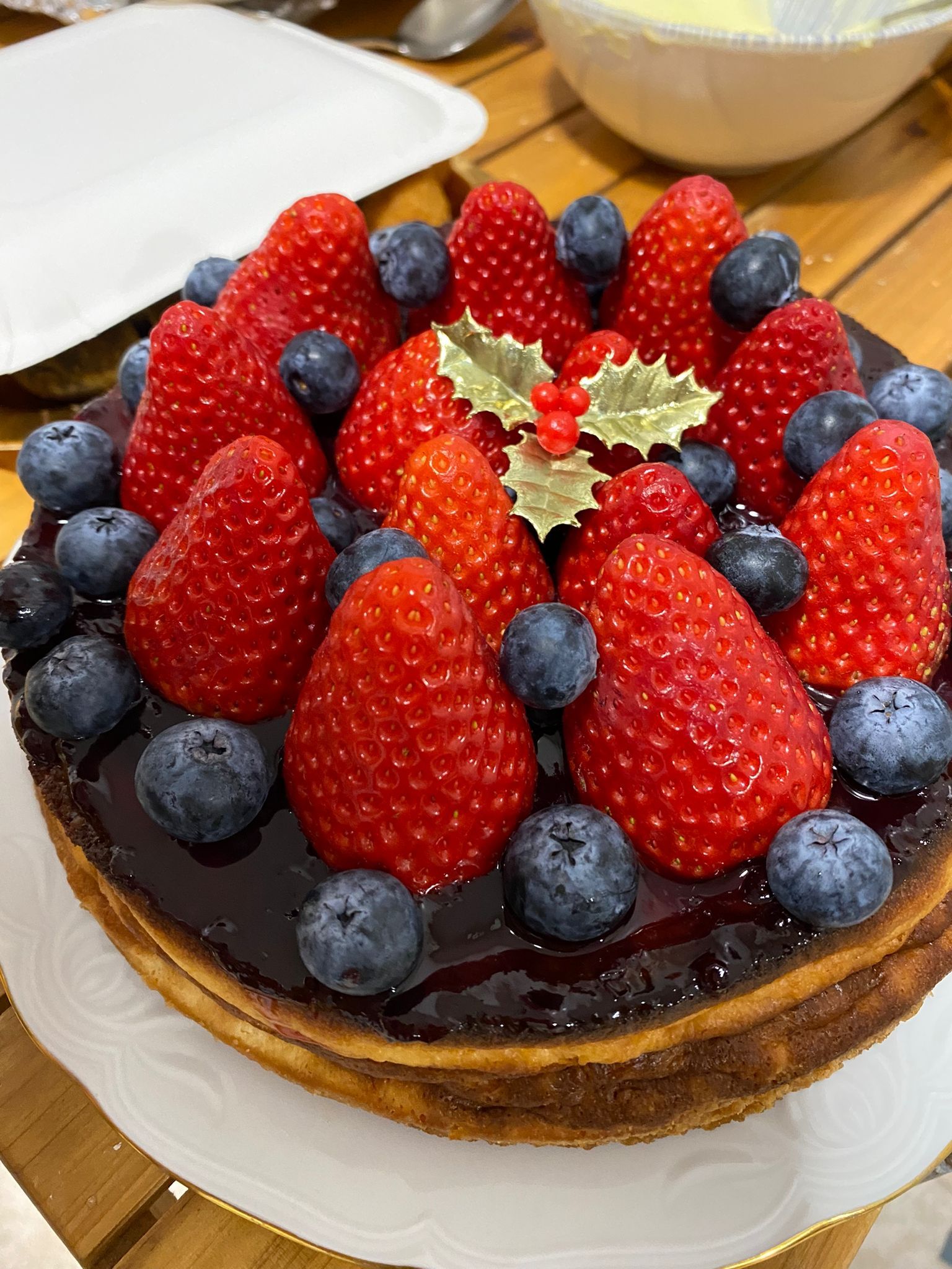 Un pastel con fresas y arándanos encima.