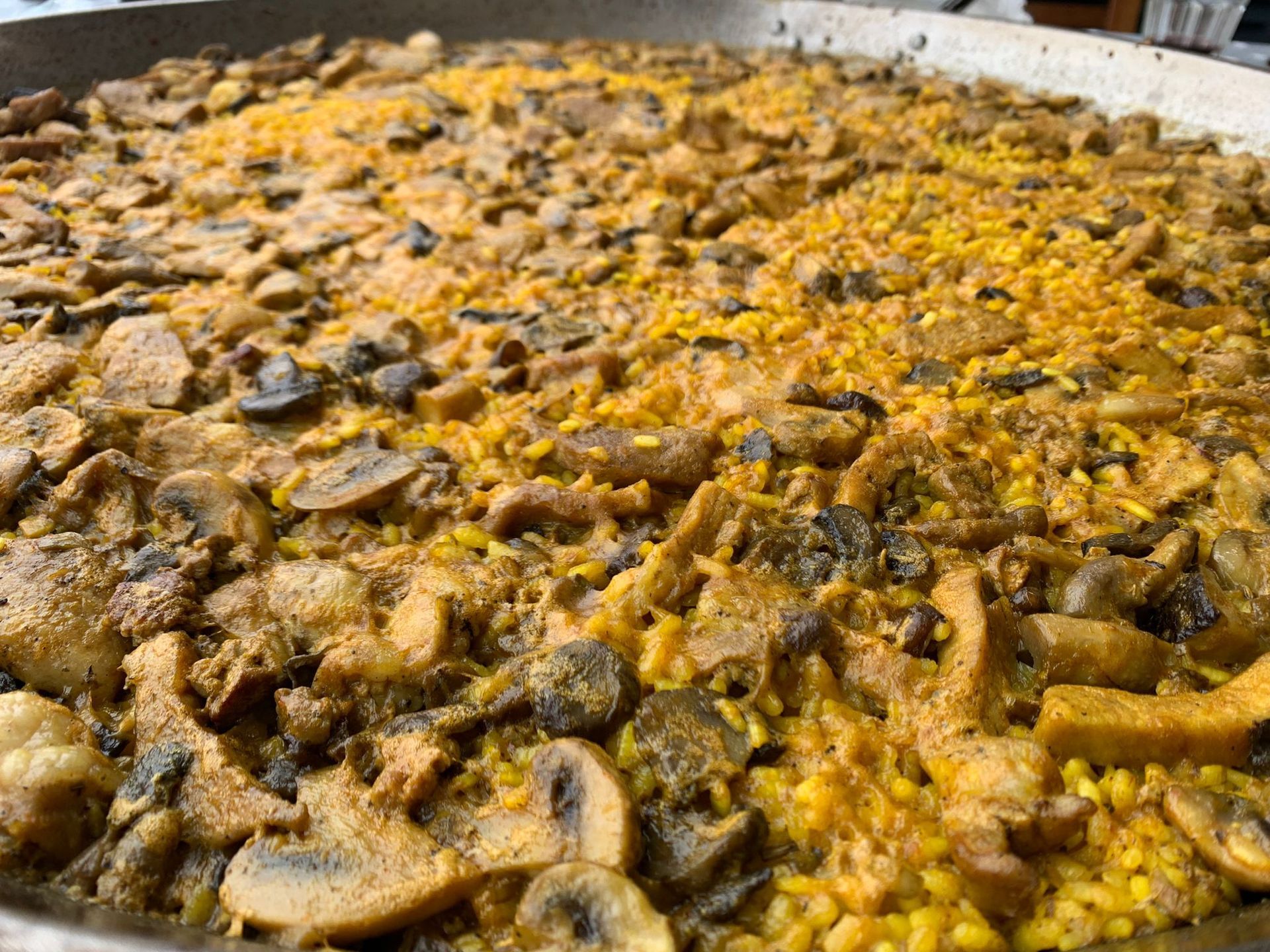 Una sartén grande llena de arroz y champiñones.