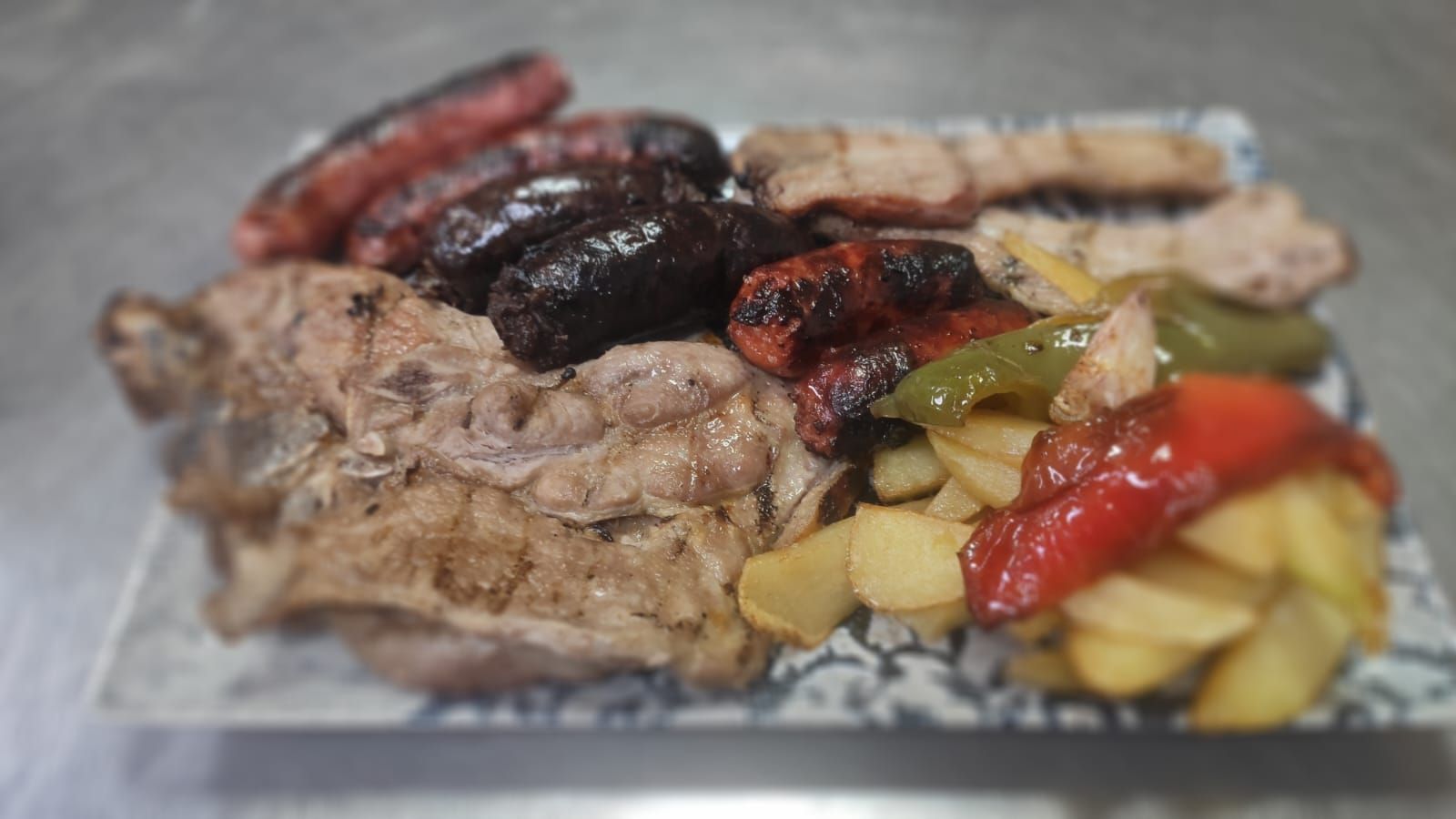 Un plato de comida con carne, verduras y patatas en una mesa.