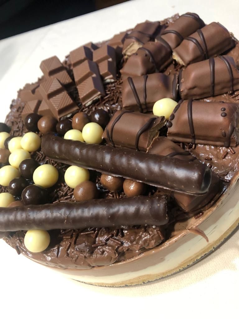 Un pastel de chocolate con muchos chocolates encima.