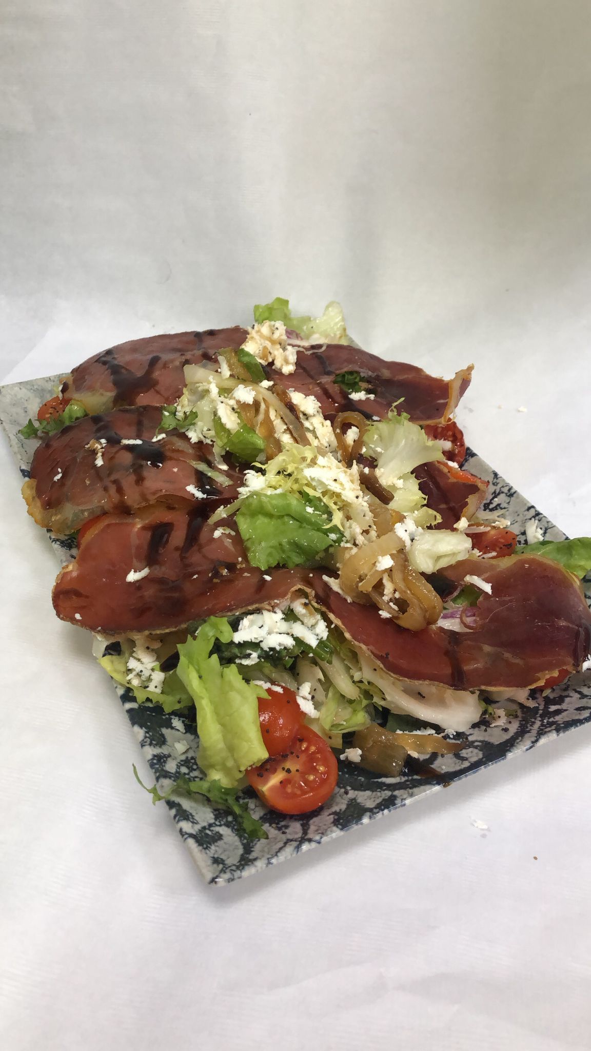 Un plato de comida con carne y verduras en una mesa.