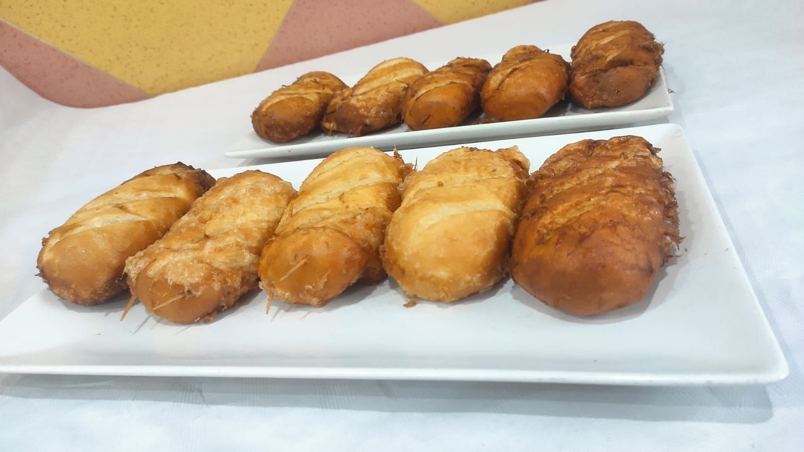 Un plato blanco cubierto con comida frita sobre una mesa.