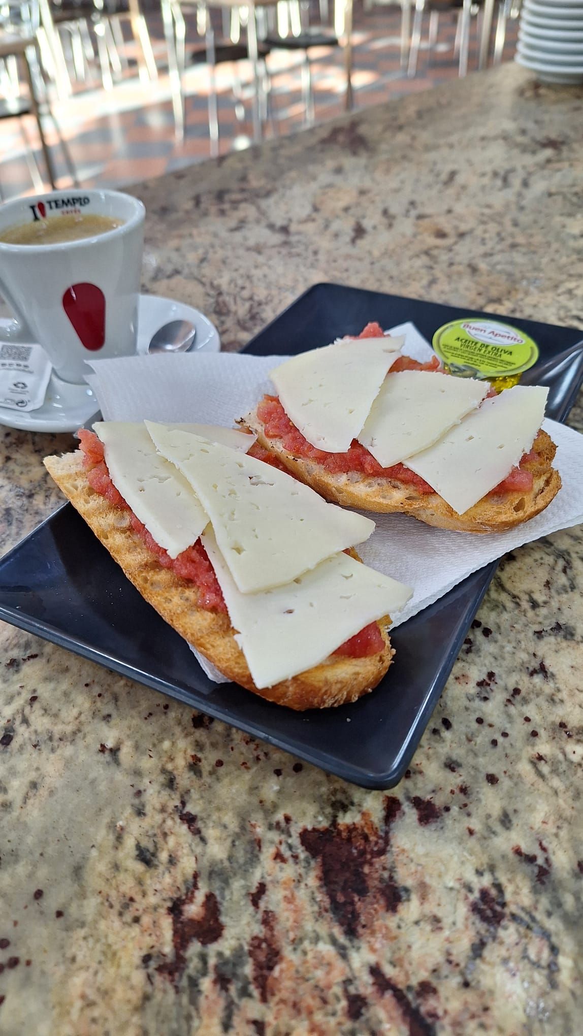 Un primer plano de un plato de comida sobre una mesa con una taza de café.