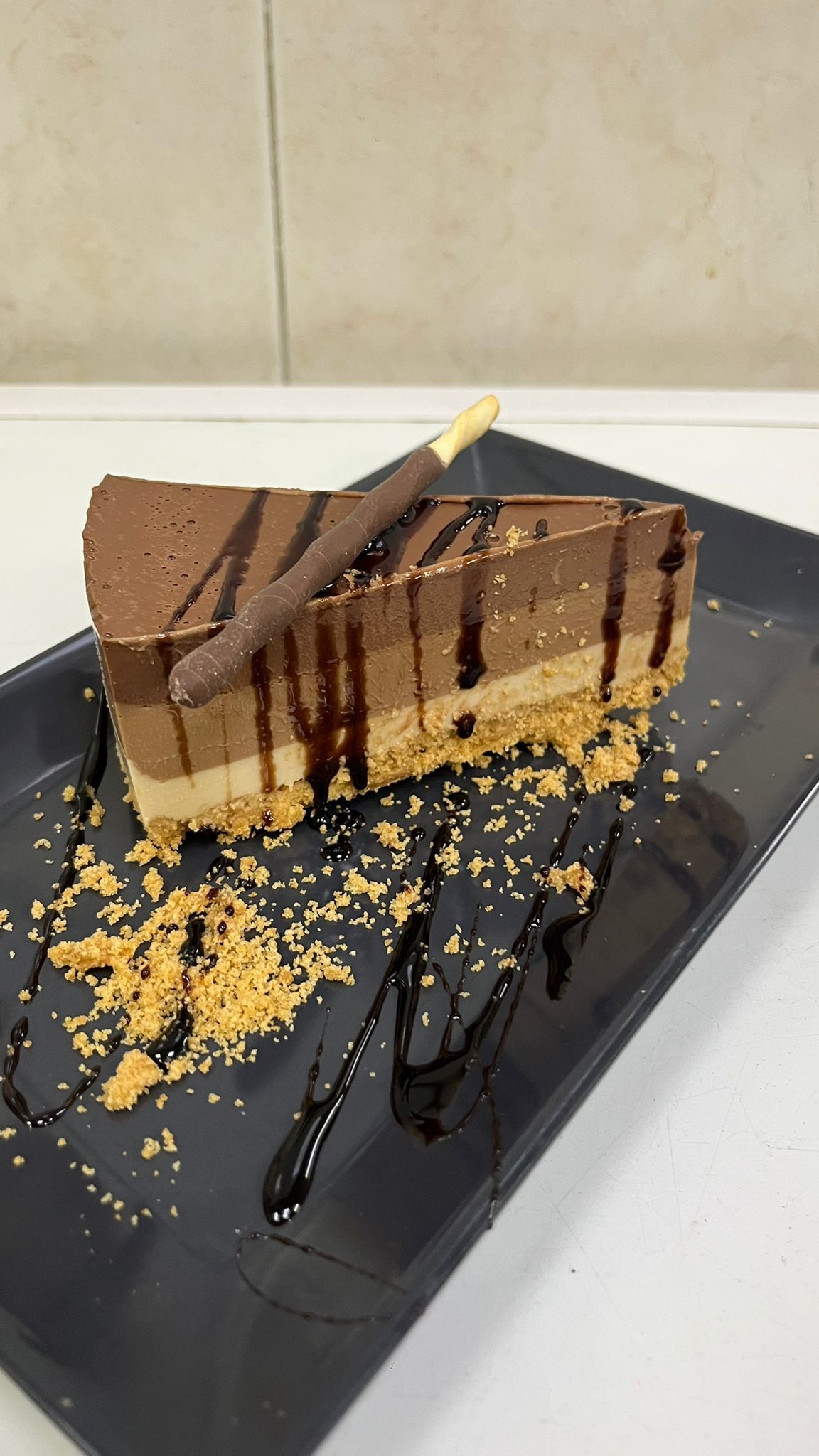 Una rebanada de pastel de chocolate está en un plato negro.