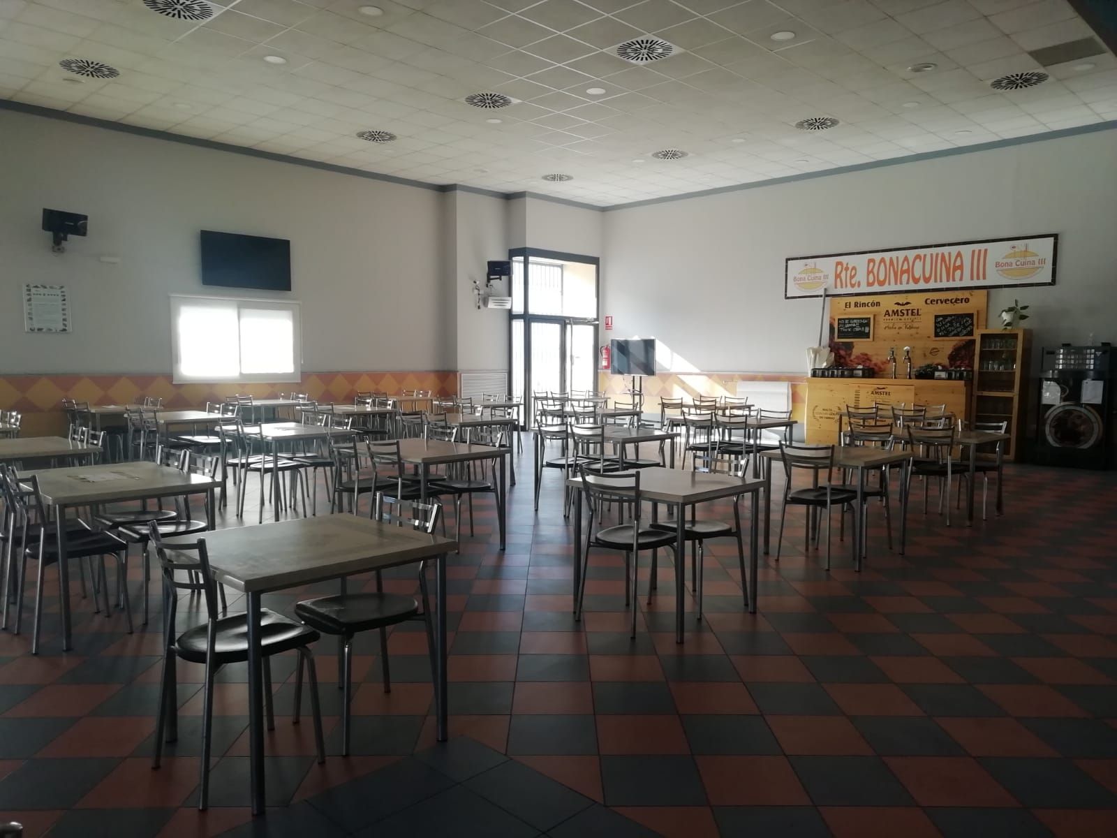 Una gran sala llena de mesas y sillas en un restaurante.