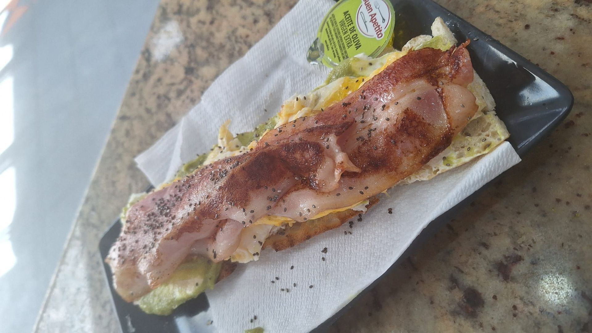 Un primer plano de un sándwich en una servilleta sobre un plato.