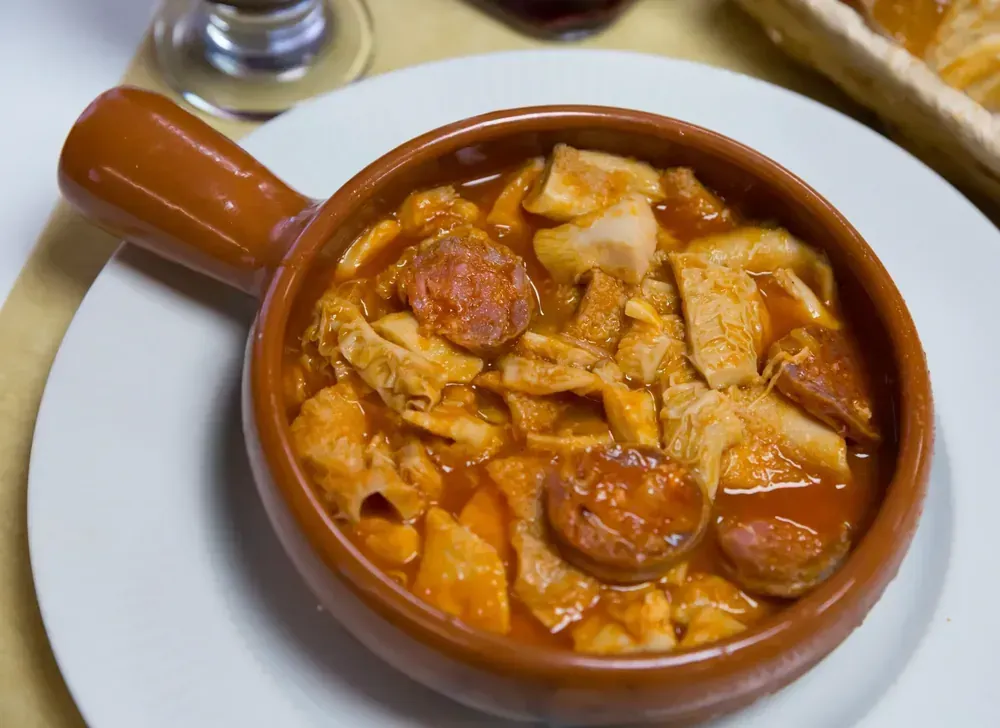 Un plato de comida con carne y salsa en un plato blanco.