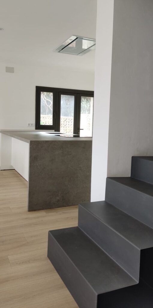 Una cocina con encimera y escaleras que conducen a ella.